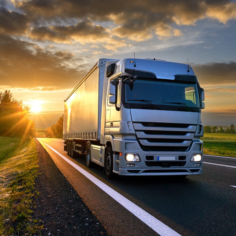 Road Transport Truck drives at sunset climate